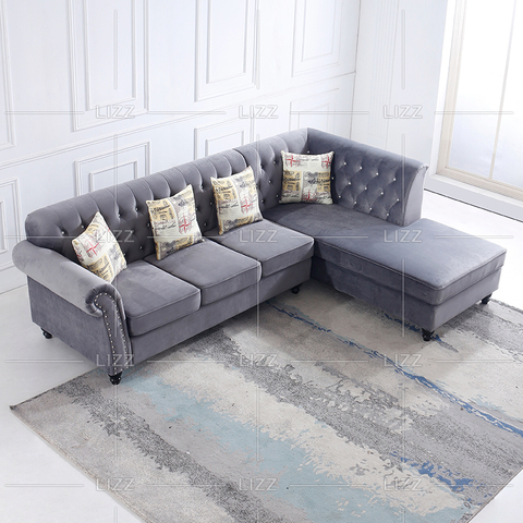 Sofá esquinero de tela gris con flores y almohadas